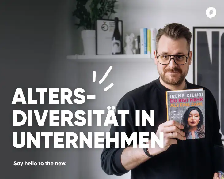 David Hillmer, CEO von HelloAgile, steht und hält ein Buch von Irène Kilubi mit dem Titel "Du bist mehr als eine Zahl" in der Hand. Im Bildtext steht: "Altersdiversität in Unternehmen. Say hello to the new." Der Hintergrund zeigt ein Regal mit Büchern und Dekorationsgegenständen.