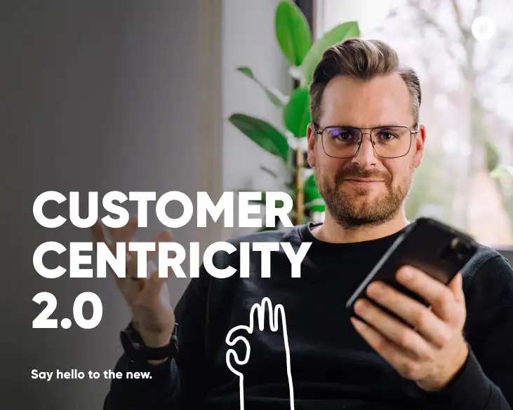 David Hillmer, CEO von HelloAgile, sitzt und hält ein Smartphone in der Hand. Er trägt eine Brille und ein schwarzes Oberteil. Im Bildtext steht: "Customer Centricity 2.0. Say hello to the new." Der Hintergrund zeigt eine moderne, helle Umgebung mit einer Pflanze.