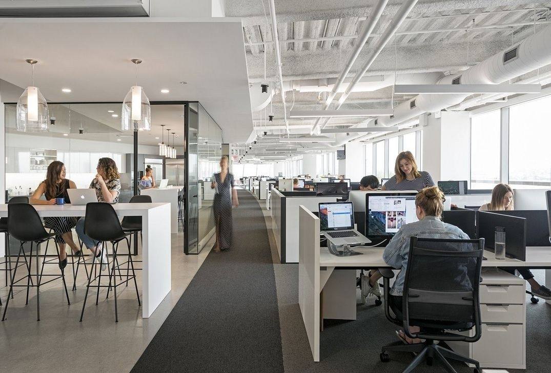 Open-plan corporate office with employees at networked workstations