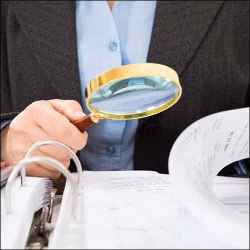 Magnifying glass reviewing documents