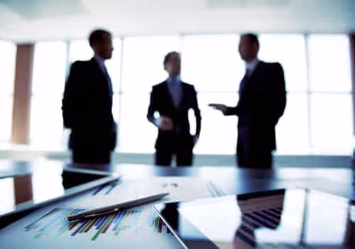 Three business people standing around a table in an office