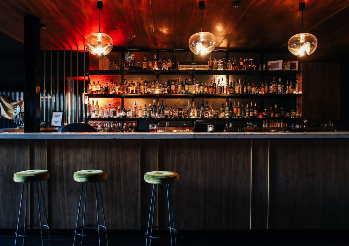 truDigital digital signage menu board displaying drink specials in a modern restaurant bar with stylish interior lighting