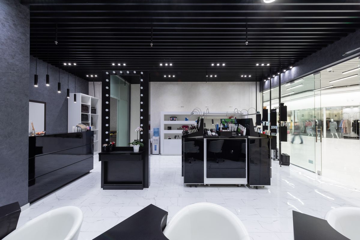 truDigital digital signage screen in a modern salon reception area showing promotions and stylist availability