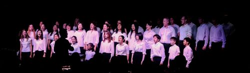 The community choir and youth choirs singing in concert.