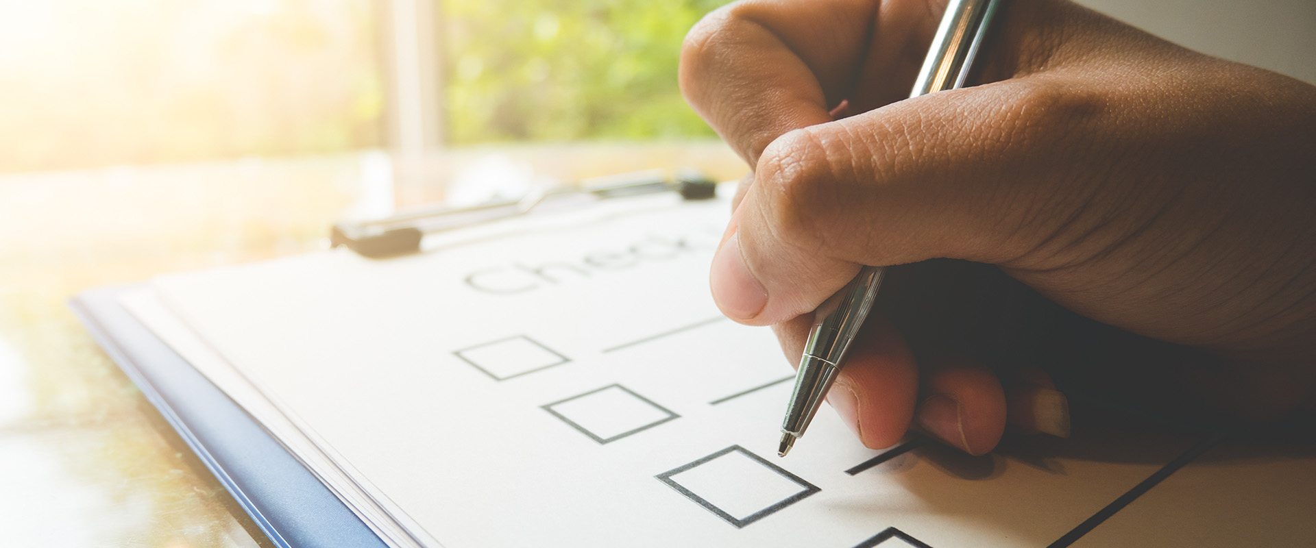 A hand filling out a checklist