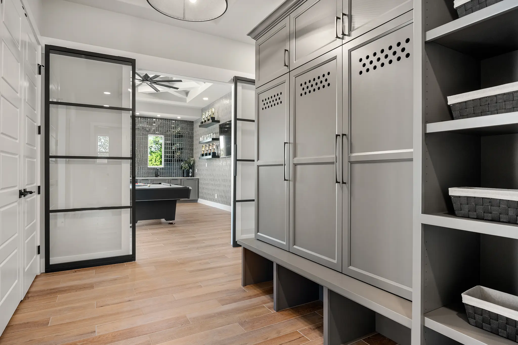 Elegant locker room with modern storage leading to a stylish game lounge in a Pecan Springs custom estate.