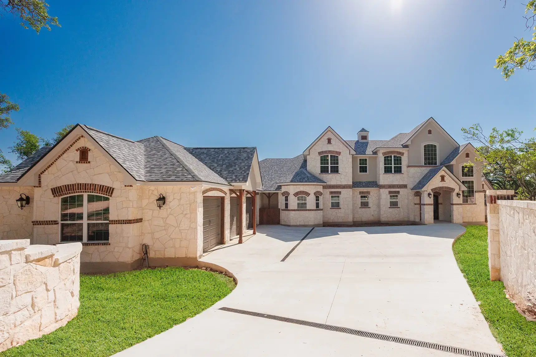 Elegant two-story custom home by KC Custom Homes in Cordillera Ranch, Boerne, Texas featuring a limestone and brick exterior, oversized garage, and private driveway in a prestigious gated community.