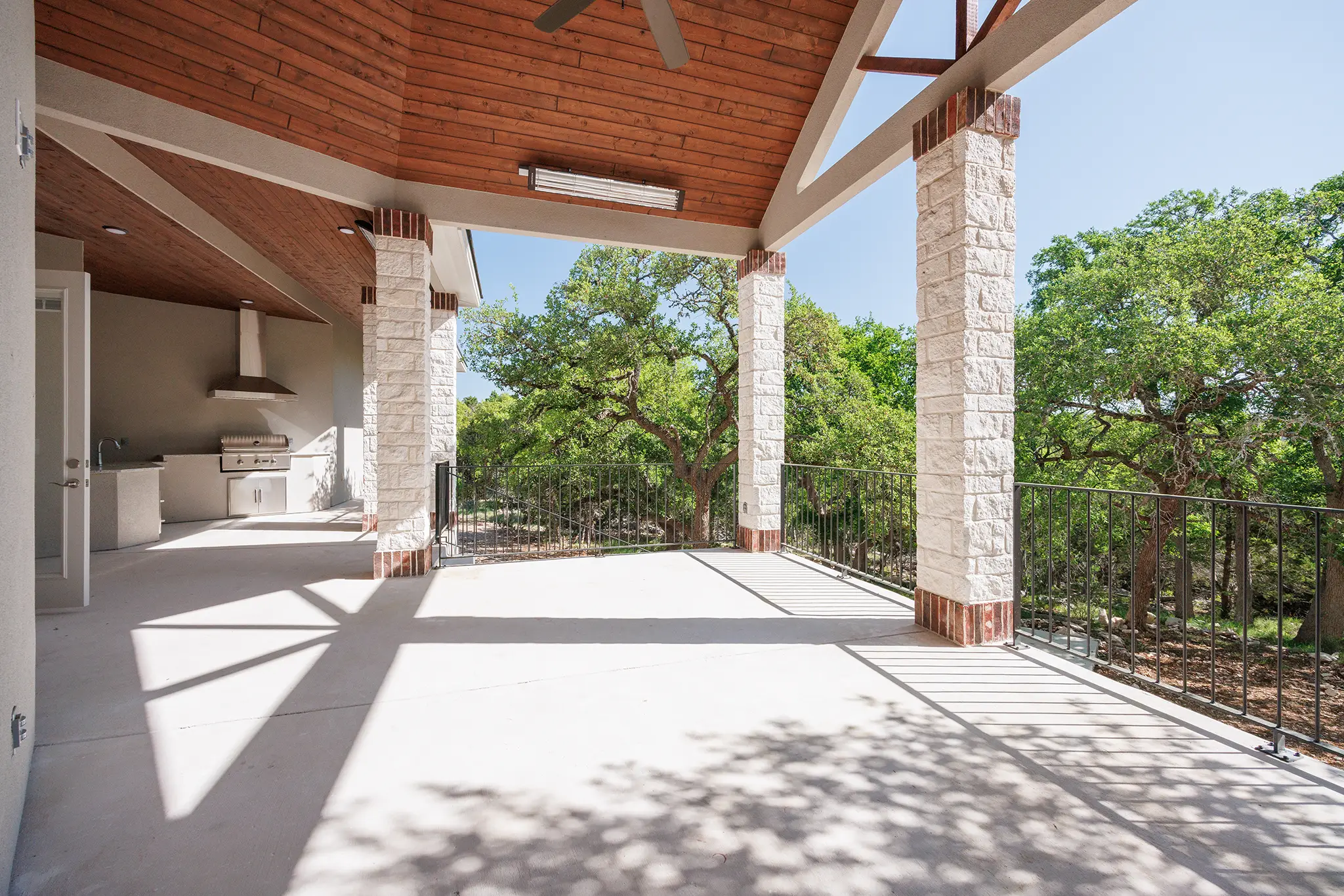 Spacious outdoor living area in Cordillera Ranch with built-in kitchen and panoramic Hill Country views, designed by KC Custom Homes for resort-style entertaining in Boerne, Texas.