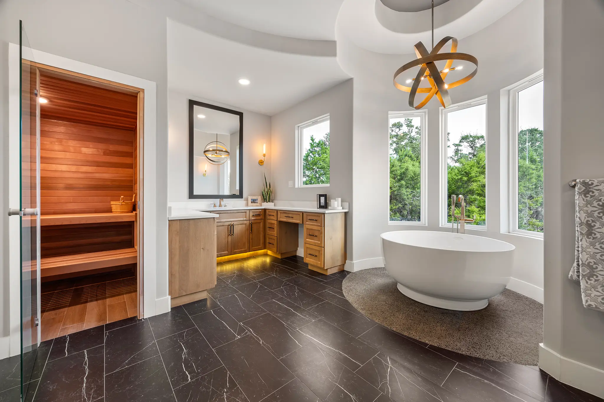 Spa-style primary bathroom with freestanding tub, wood vanity, and in-home sauna crafted by KC Custom Homes in the Texas Hill Country