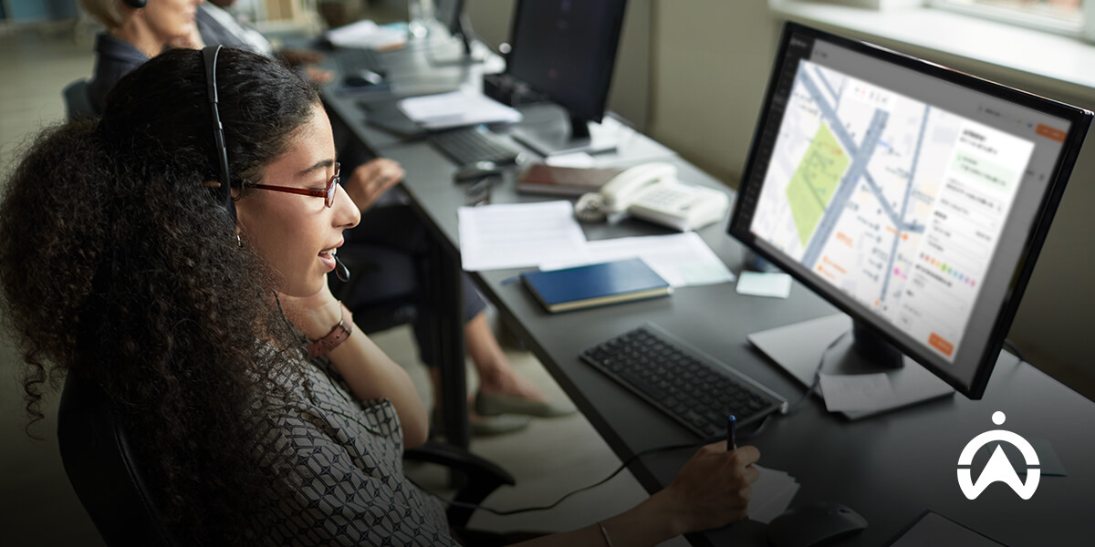 Cartrack geofencing support with woman using headset and computer showing map and data.