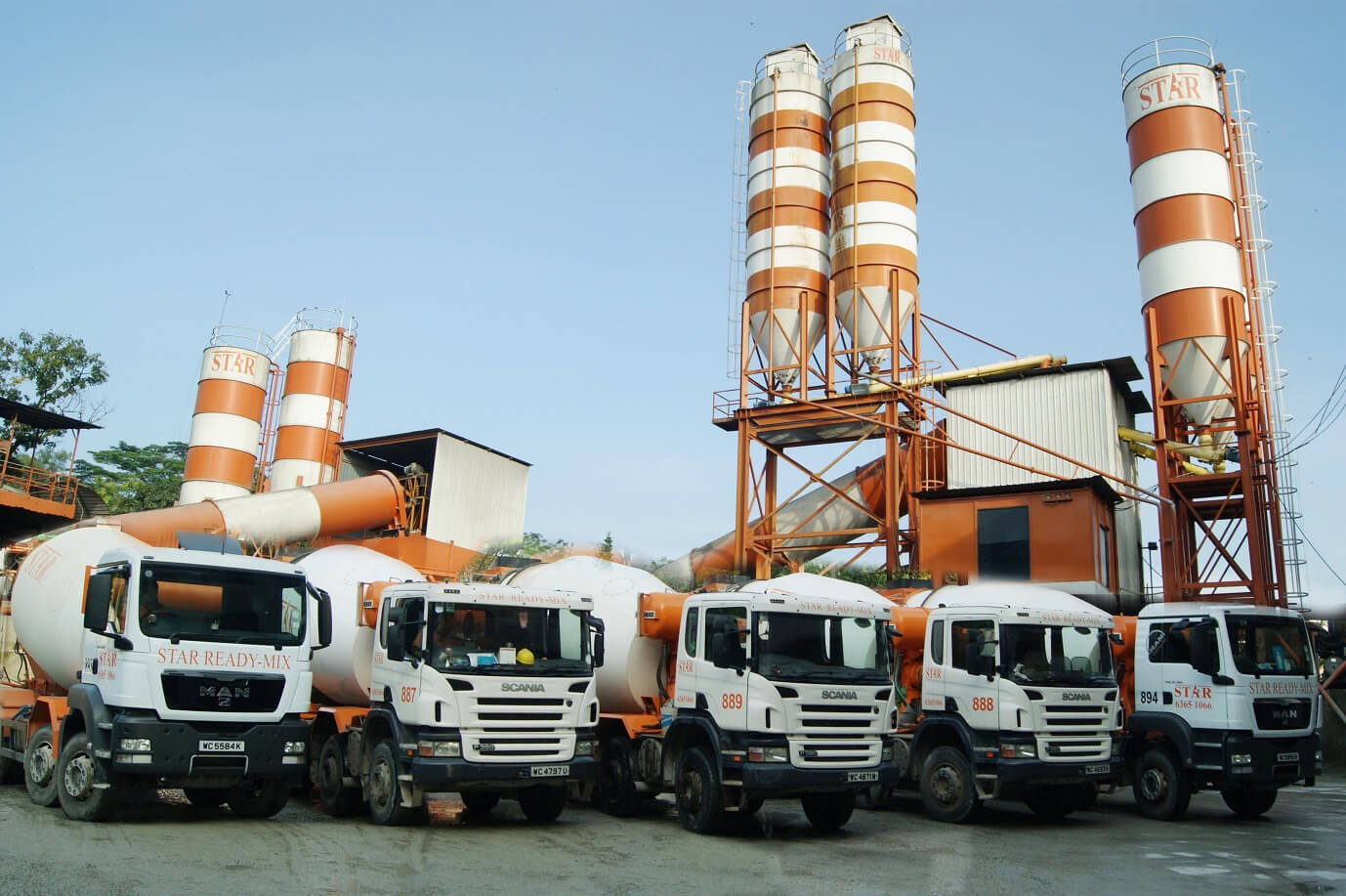 Cartrack Singapore's fleet of IoT-enabled orange and white concrete mixer trucks parked at an industrial site