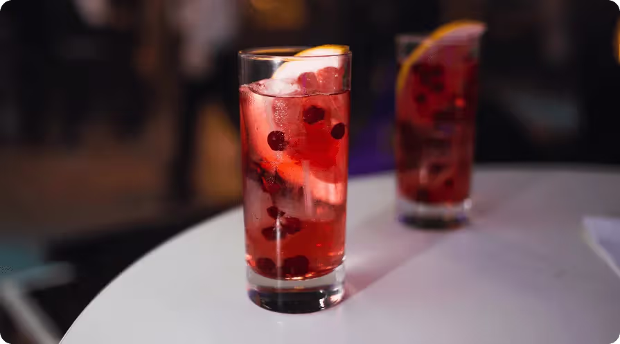 A tall glass filled with liquid and a slice of lemon