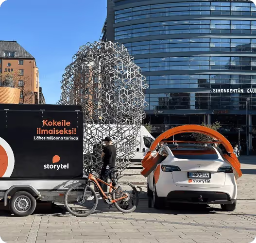 A person on a bike next to a small car