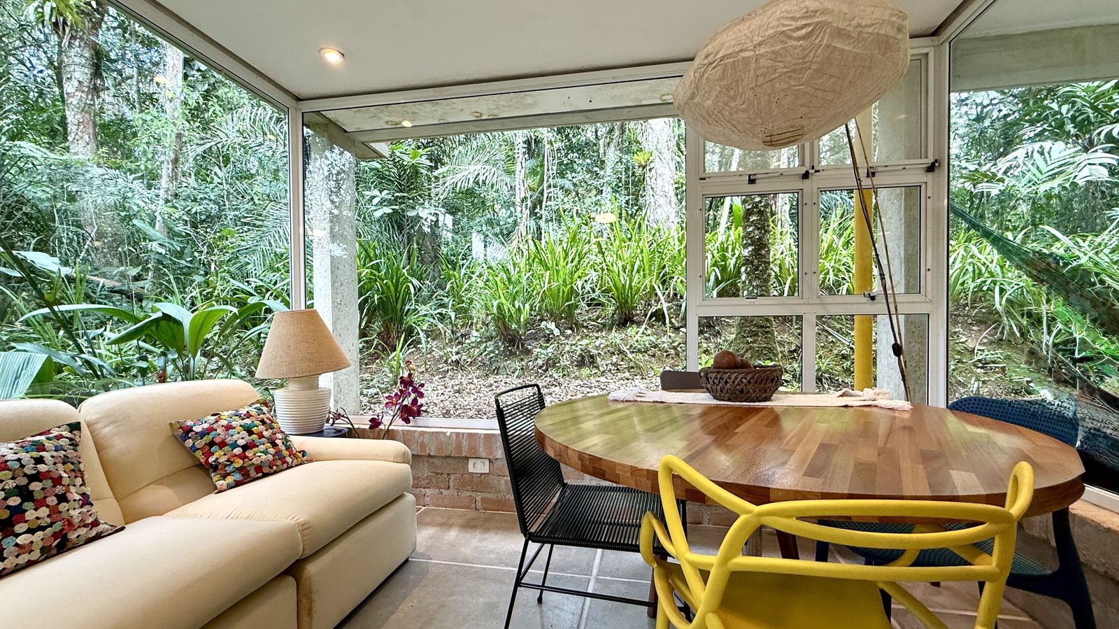 Ambiente com mesa de jantar e vista para natureza – Casa 812
