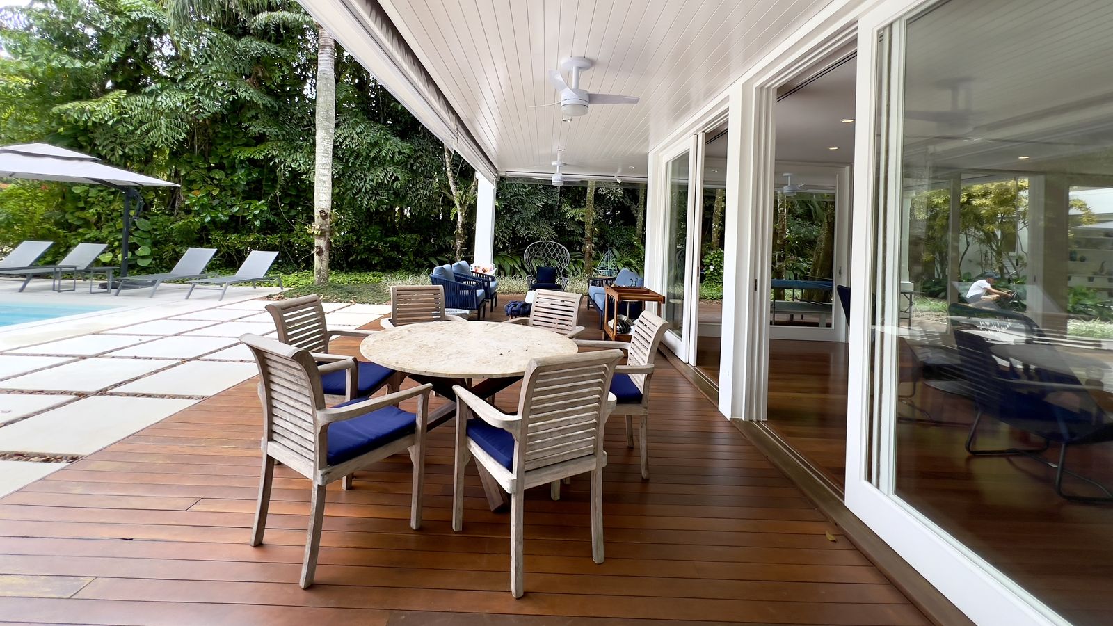 Varanda com piso de madeira e vista arborizada – Casa 798