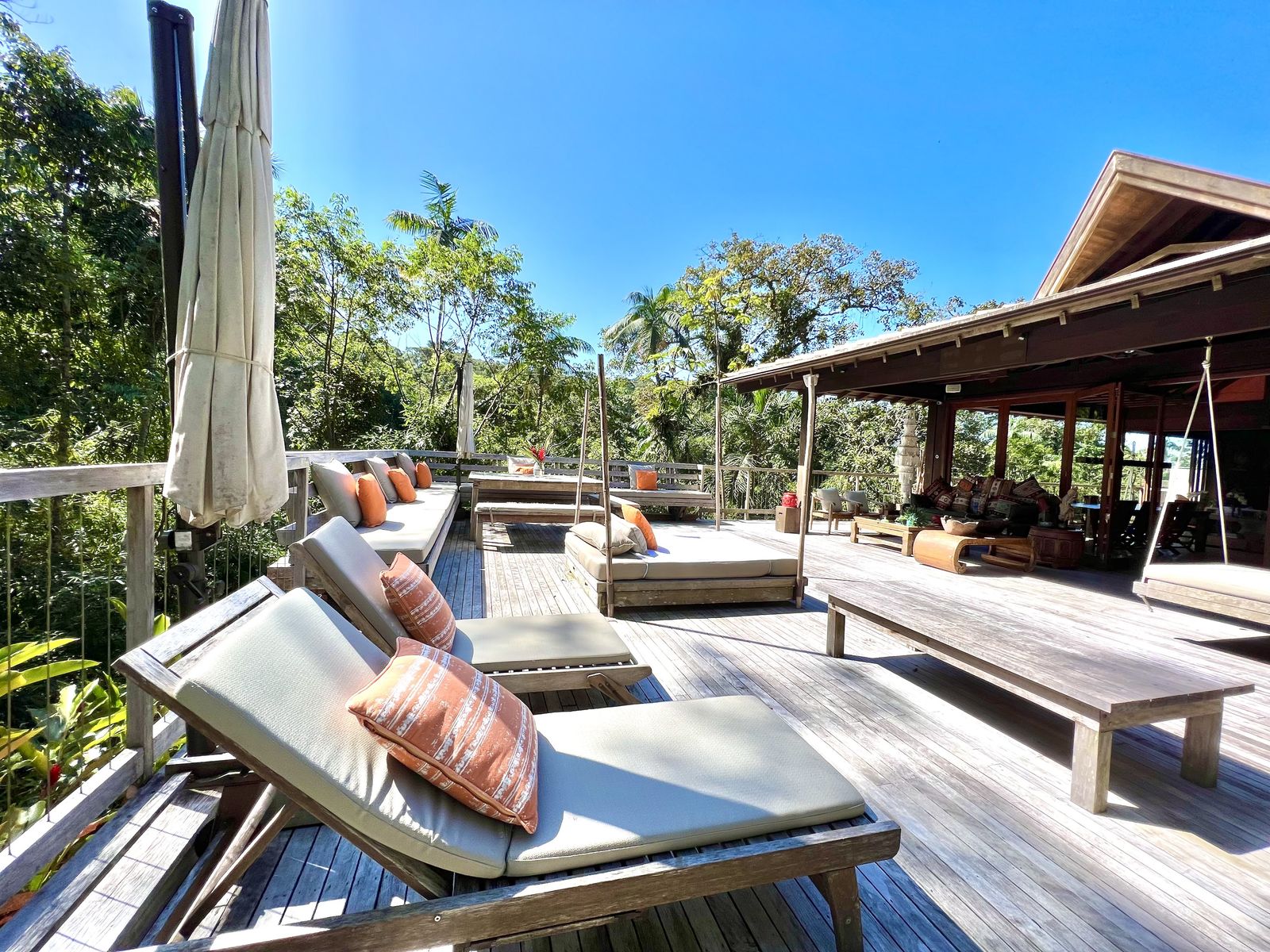 Deck amplo com espreguiçadeiras e área sombreada – Casa 778