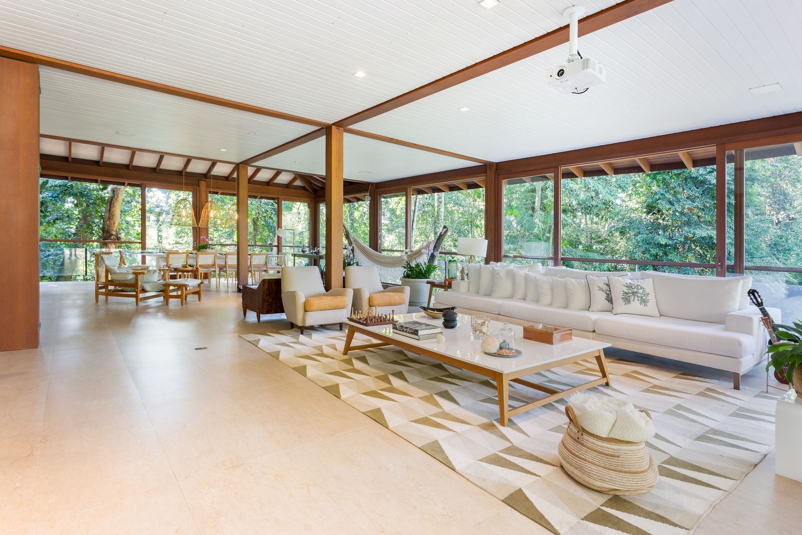 Área de descanso com espreguiçadeiras e deck em madeira – Casa 777