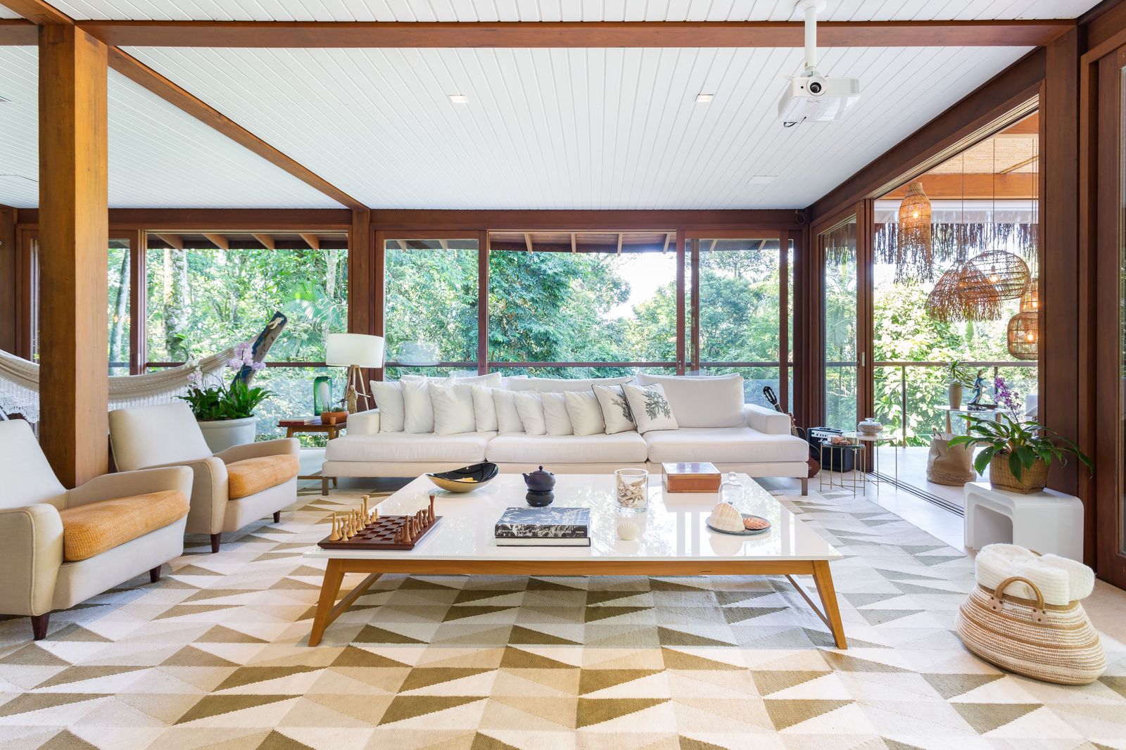 Hall com painel vazado em madeira e escultura – Casa 777