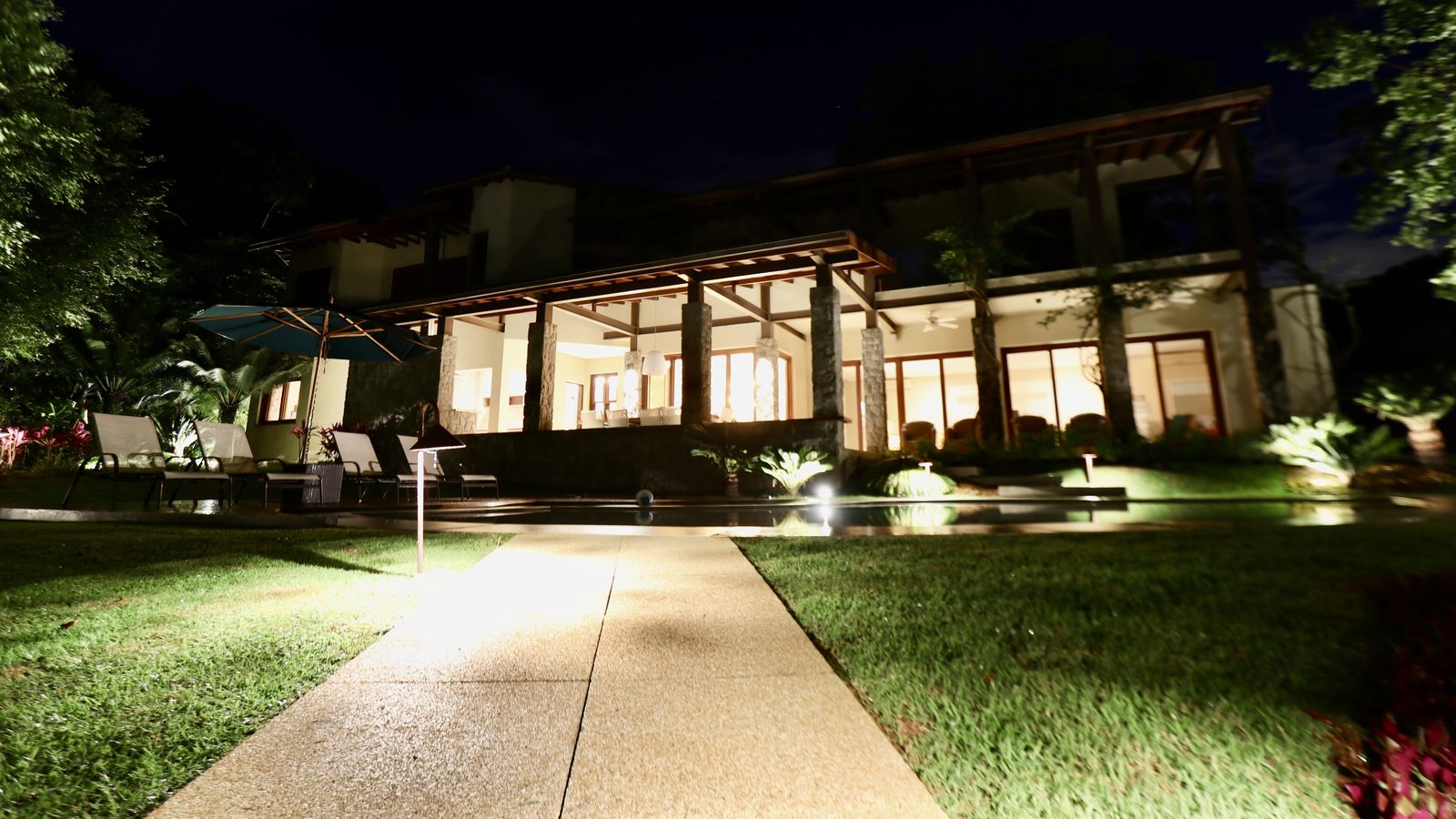 Espaço coberto com pilares de pedra e vista piscina – Casa 706