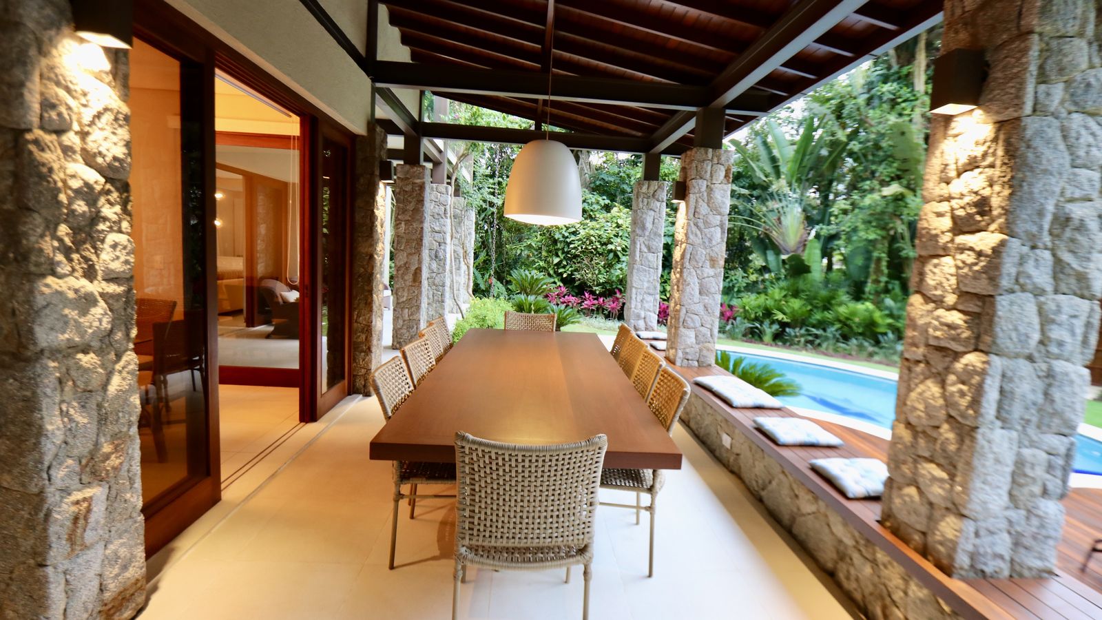 Corredor de varanda com pilares e vegetação ao fundo – Casa 706