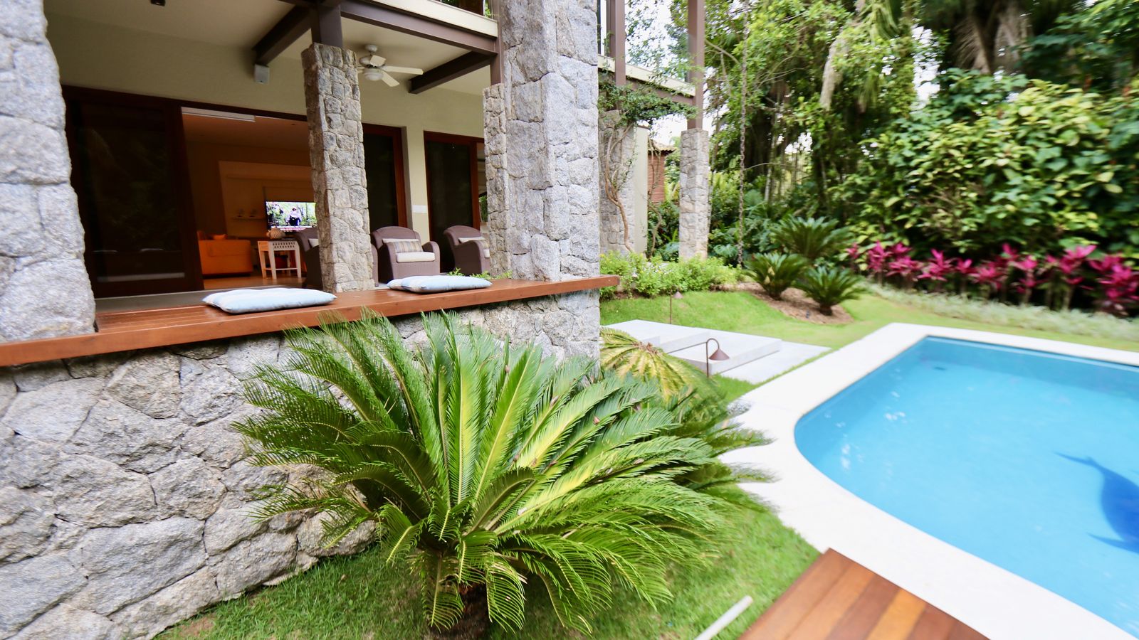 Varanda integrada com estrutura de madeira e pilares de pedra – Casa 706