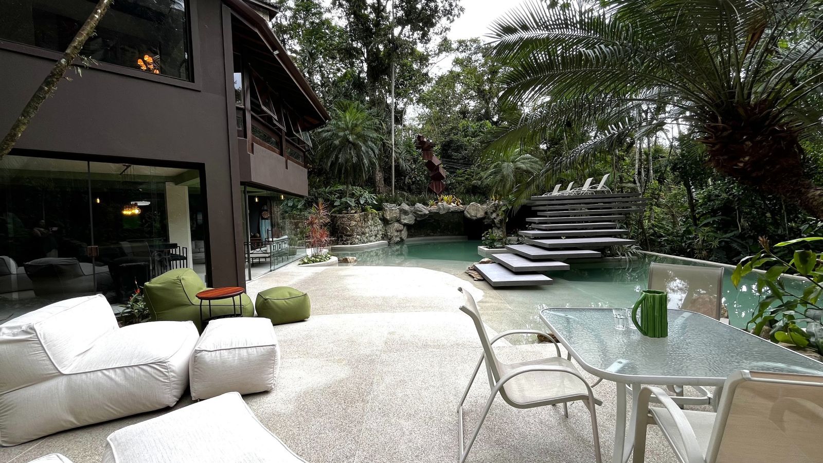 Área externa com mesa e lounge – Casa 852