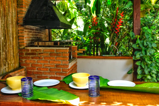 Fachada posterior com piscina e jardim tropical – Casa 702