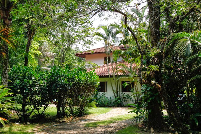 Varanda integrada ao jardim com iluminação noturna – Casa 702