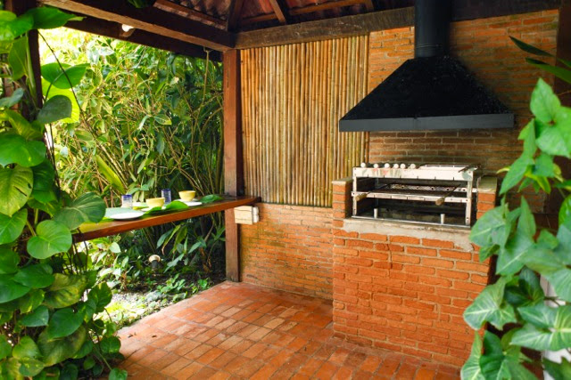 Varanda integrada ao jardim com rede e estar – Casa 702