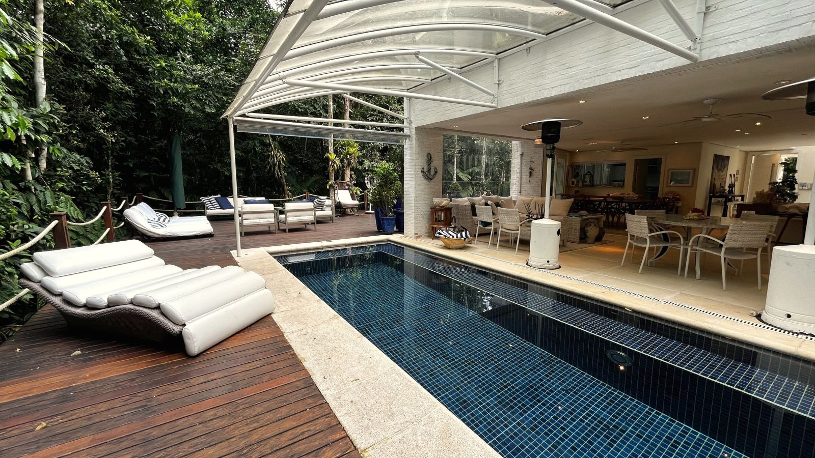 Deck da piscina cercado de mata