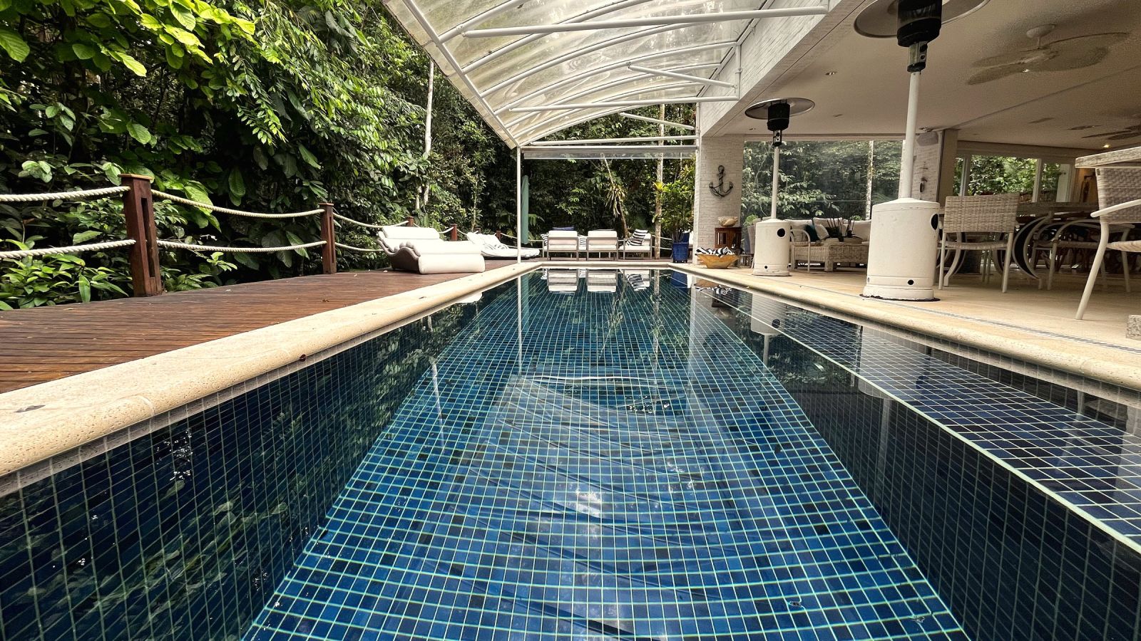 Piscina com cobertura transparente e deck de madeira