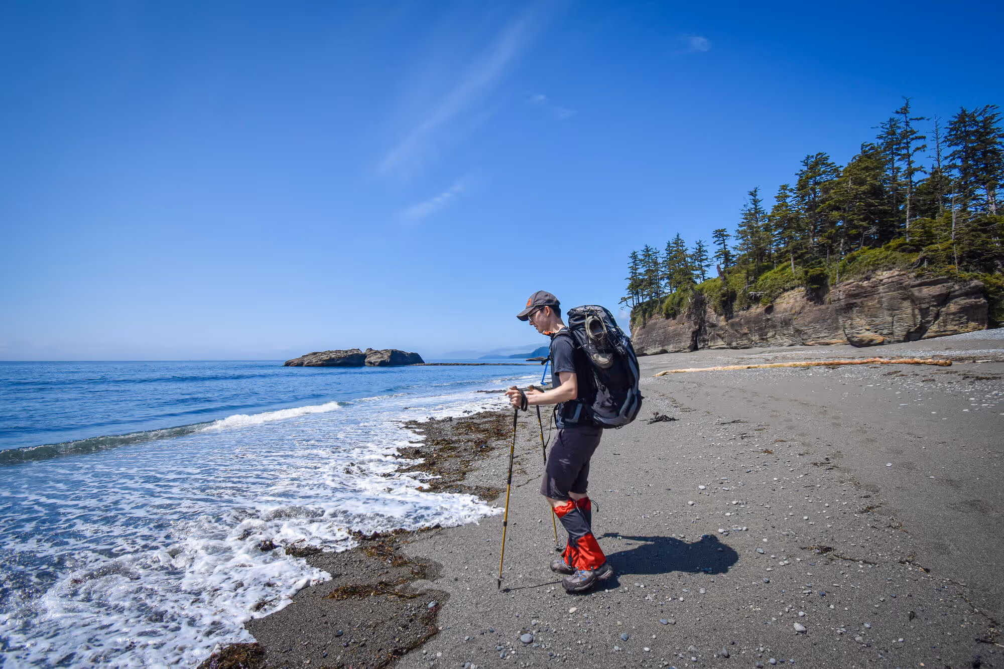 hiker looking at the wave coming in on the beach
