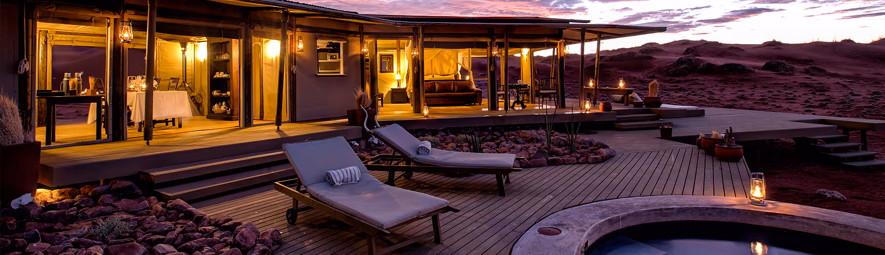 A view over the deck and plunge pool looking into the Wolwedans Mountain View Suite at sunset.