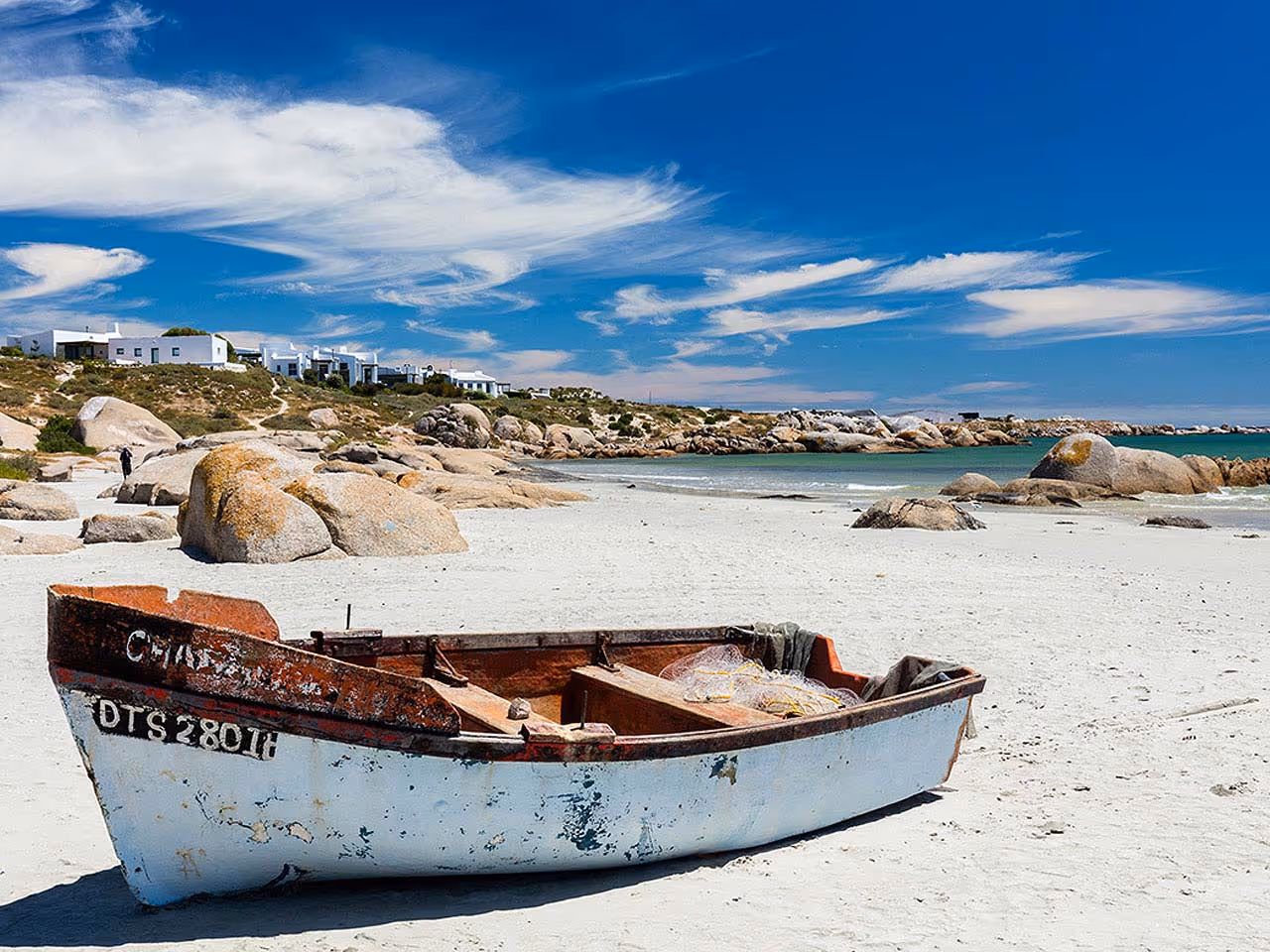 A fishing boat on the white sands of the beach on the West Coast.