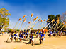 A group ofSwazi woman in traditional dress walking carrying long sticks of grass. 