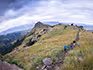 A view of three people walking on a trail in the mountains of Swaziland. 