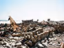 Two people standing among the rusted remains of a shipwreck on the Skeleton Coast.