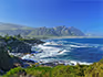A view over the ocean and a small town at the base of the mountains in the distance on the Garden Route. 