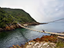 A view of Storms River and the bridge crossing with people on the bridge. 