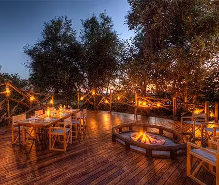 Evening enchantment at Camp Moremi: A magical dinner setting, surrounded by the beauty of the wilderness, creating unforgettable moments under the African night sky.