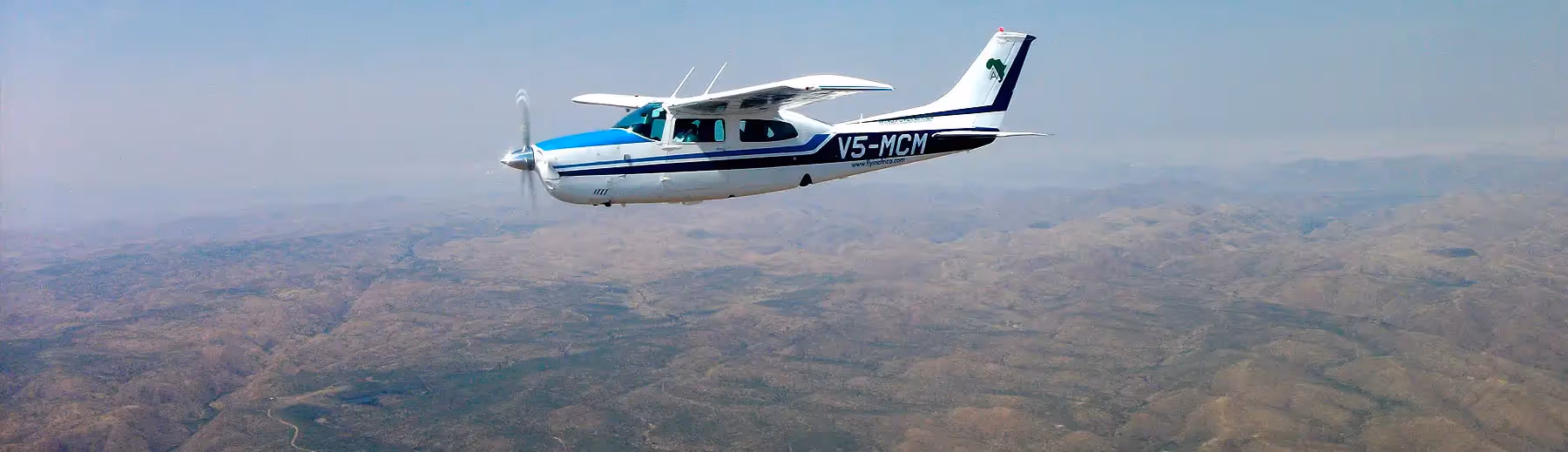 A view of a Cessna 210 flying over the green desert oasis in Botswana.