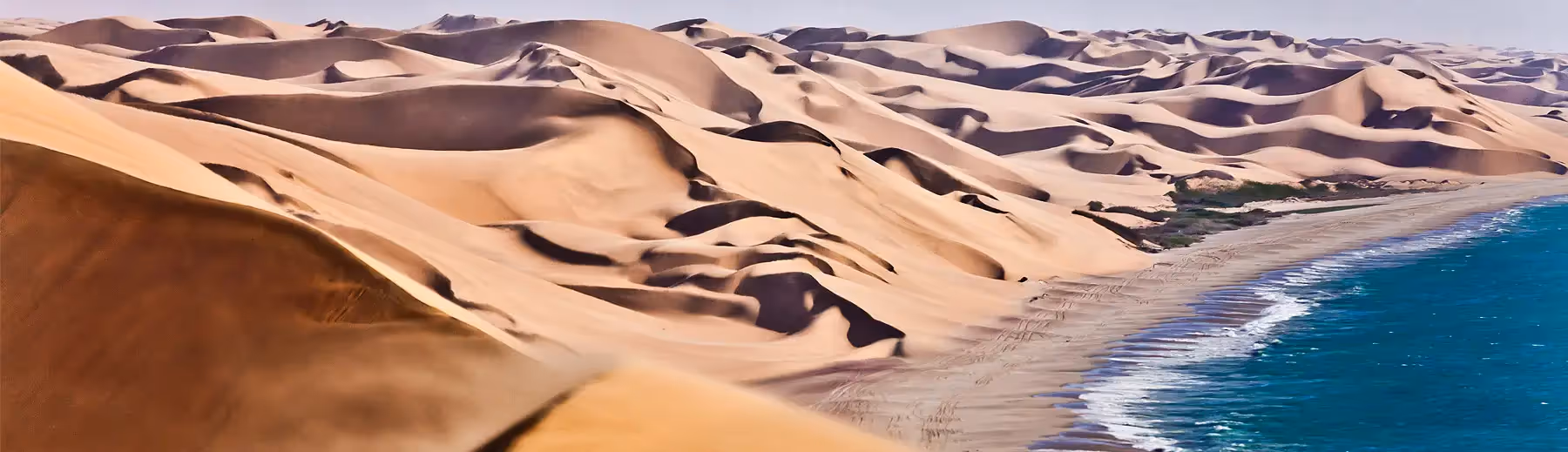 A panoramic view of the Skeleton Coast where the endless dunes meet the beach and cold Atlantic Ocean. 