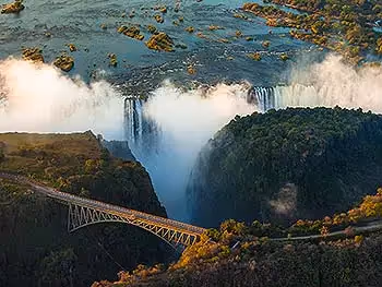 A view over the famous bridge at Victoria Falls with the falls in the background. 
