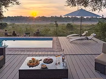 Snacks on the swimming pool deck with guests sitting enjoying the sunset.