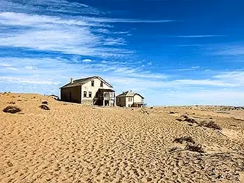 Two abandoned houses in the distance at Kolmanskop Ghost Town.