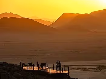 A couple at sunset on the viewing deck at Desert Homestead Outpost.