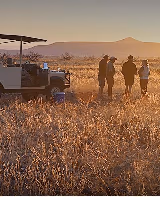 An endless landscape of the Namib Desert from a red sand dune overlooking an open plain and the distant mountains. 