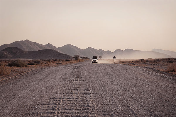 Long, remote gravel road in Namibia highlighting distance and scale