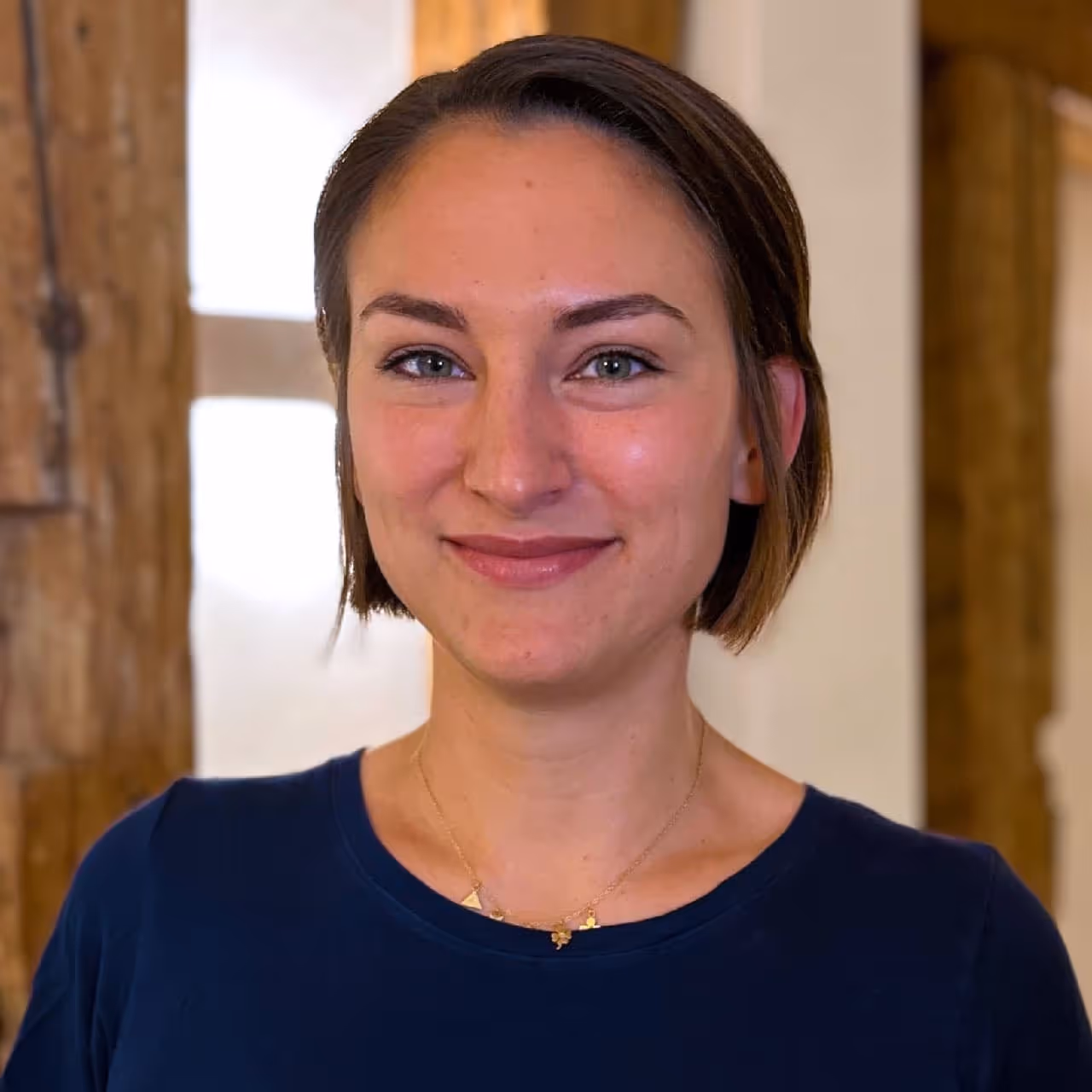 Portrait Ärztin Magdalena Wirth, lächelnd mit dunklen kinnlangen Haaren