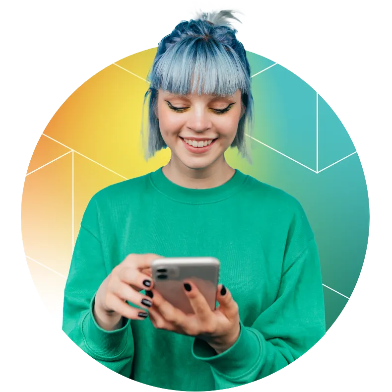 Young teen with blue hair looking at phone and smiling